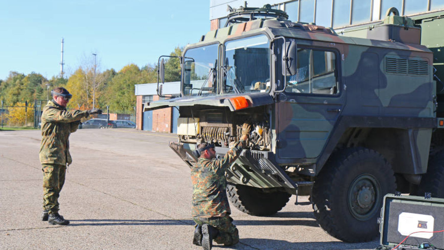 Two men are servicing a military vehicle