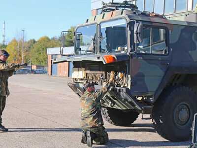 Two men are servicing a military vehicle